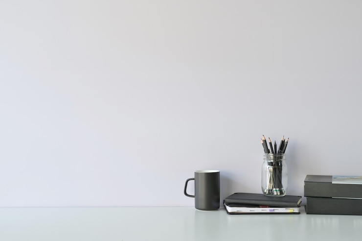 Foto modellarbeitsplatzschreibtisch und kopienraumbücher, -kaffee und -bleistift auf weißem schreibtisch.
