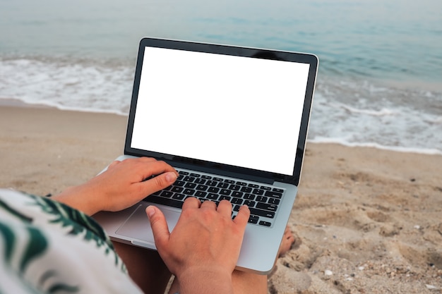 Modellbild der Frau, die auf Laptop mit leerem Desktop-Bildschirm verwendet und tippt