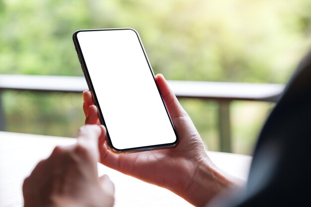 Modellbild einer Frau, die ein Mobiltelefon mit einem leeren weißen Desktop-Bildschirm hält