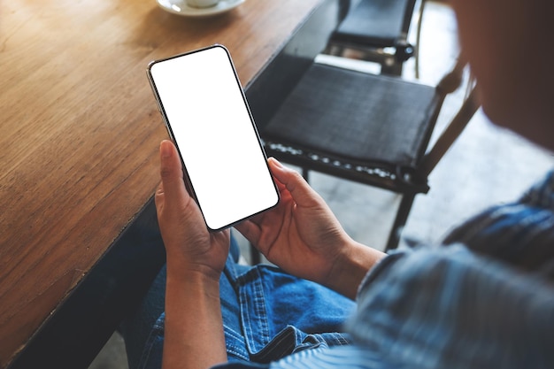 Modellbild einer Frau, die ein Mobiltelefon mit einem leeren weißen Desktop-Bildschirm hält