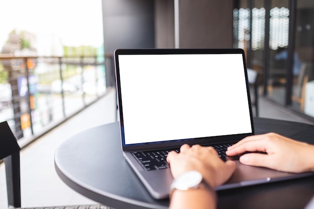 Modellbild einer Frau, die einen Laptop mit leerem weißem Desktop-Bildschirm im Café verwendet und tippt