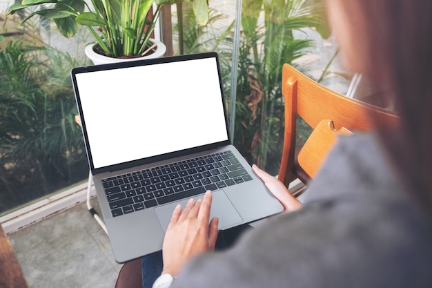 Modellbild einer Frau, die Laptop-Touchpad mit leerem weißem Desktop-Bildschirm verwendet und berührt, während sie im Café sitzt