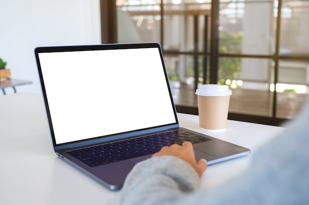 Modellbild einer Frau, die Laptop-Touchpad mit leerem weißem Desktop-Bildschirm verwendet und berührt