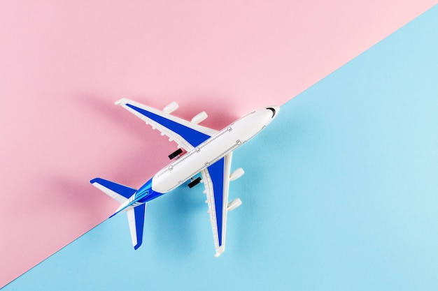 Modellflugzeug, Flugzeug auf einem rosa und blauen Hintergrund. Sommerreisekonzept