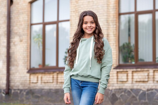 Modelo de adolescente feliz posando en un estilo casual de moda al aire libre borroso