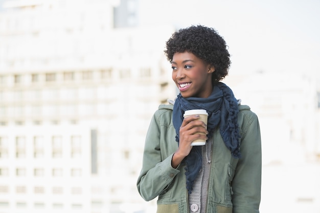 Modelo alegre alegre que mantem o café