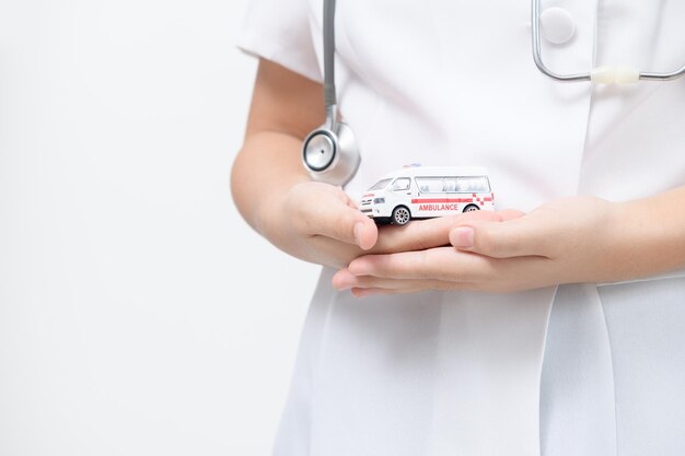 Foto modelo de ambulancia en la mano del médico aislado en fondo blanco servicio de transferencia de paciente o seguro