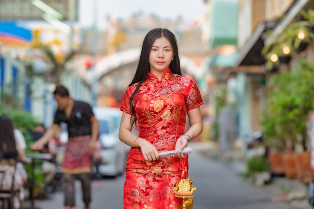 Modelo asiático bonito que veste o ano novo chinês tradicional de cheongsam.happy