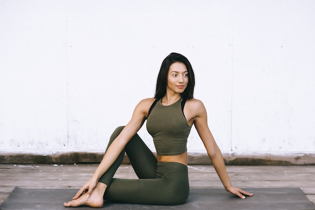 Foto modelo atractivo en pose de yoga sobre fondo blanco en ropa sexual