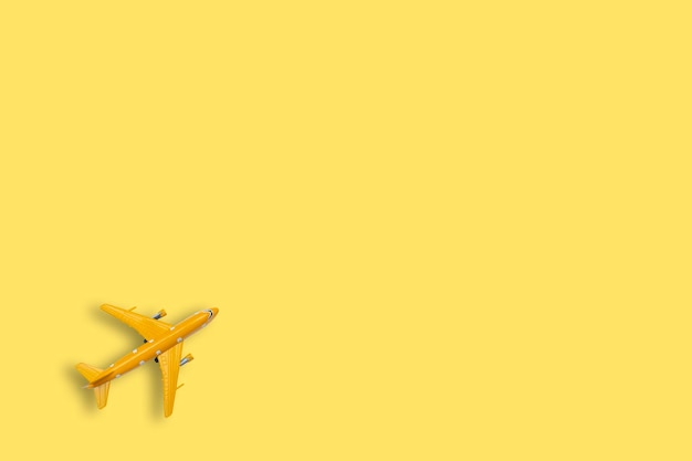 Modelo de avión amarillo sobre fondo amarillo Para uso en medios publicitarios