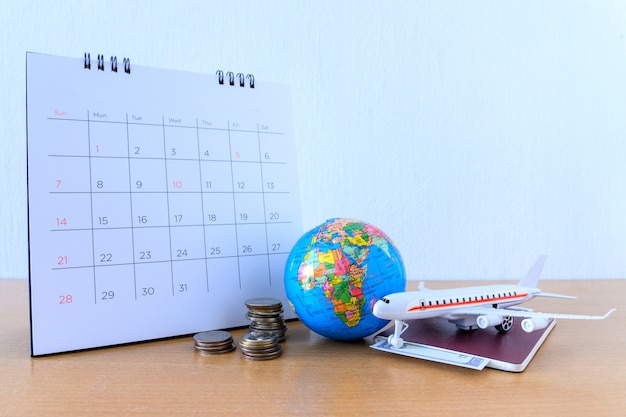 Modelo de avión con calendario de papel en la mesa de madera. plan de viaje