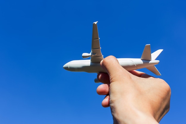 Modelo de avión en mano en el cielo soleado Conceptos de transporte de viajes transporte soñando con vacaciones