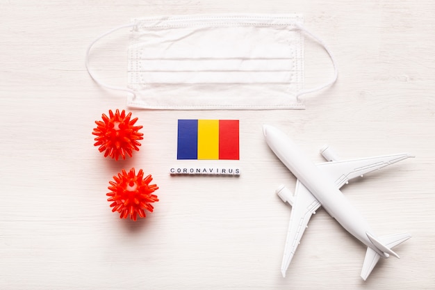 Modelo de avión y mascarilla y bandera de Rumania. Pandemia de coronavirus. Prohibición de vuelos y fronteras cerradas para turistas y viajeros con coronavirus covid-19 de Europa y Asia.