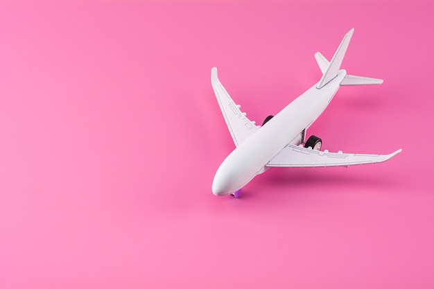 Modelo de avión sobre fondo de papel rosa.