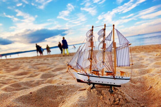 Foto modelo de barco en la playa de verano al atardecer