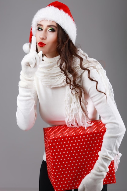 Modelo de belleza de mujer de Navidad Chica con sombrero de Santa Retrato de mujer Boca abierta Emociones verdaderas Labios rojos