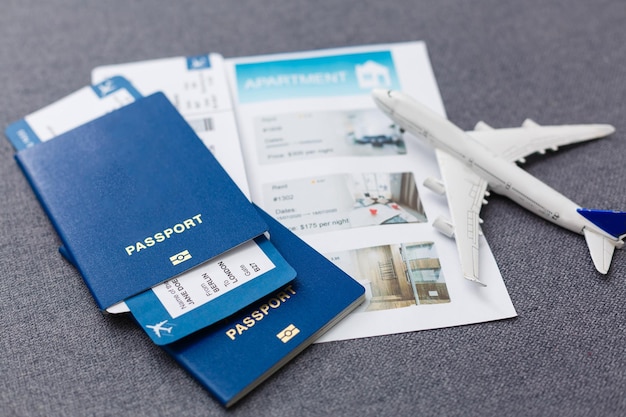 Modelo en blanco blanco de avión de pasajeros en pasaportes con tarjeta de embarque sobre fondo azul de madera rústica