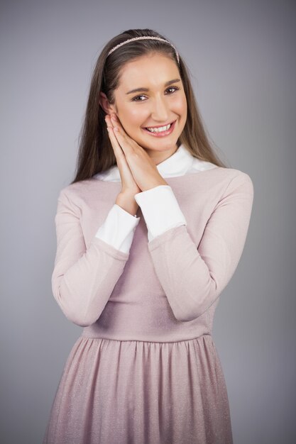 Modelo bonita alegre con vestido rosa en la presentación