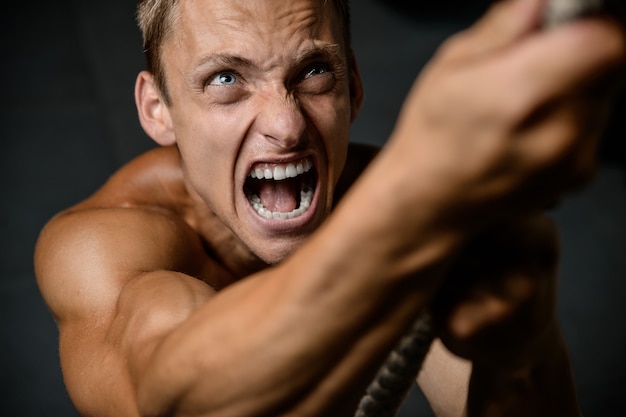 Modelo bonito jovem malhando na academia