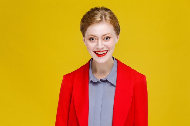 Modelo de cabeza roja jengibre en traje rojo sonrisa con dientes