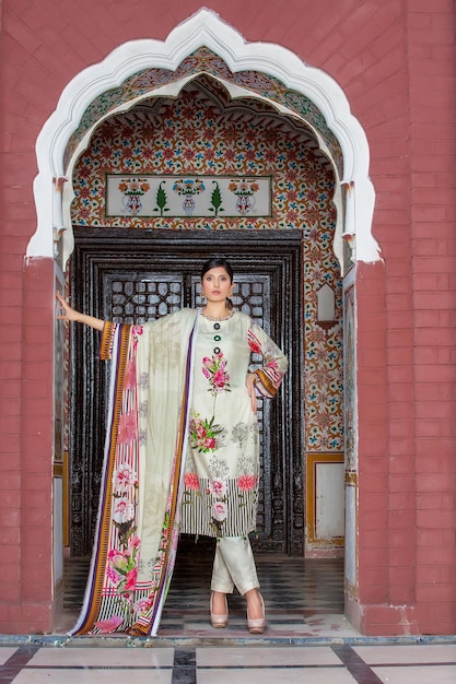 Modelo caliente posando con confianza usando un vestido tradicional paquistaní Desi en un lugar antiguo para disparar