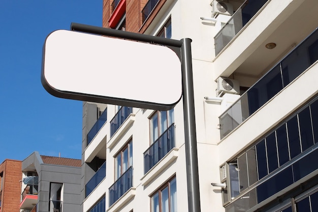 Modelo de cartel blanco en la calle contra el fondo del edificio