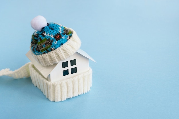 Foto modelo de casa con bufanda y gorro de punto. sistema de calefacción, invierno o temporada fría