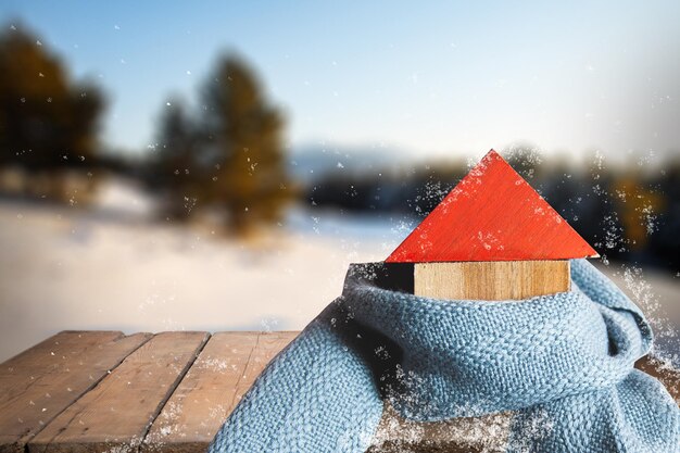 Foto modelo de casa con bufanda sobre fondo de nieve