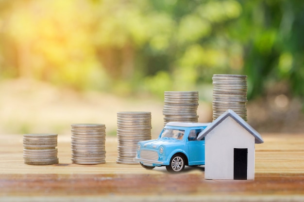 Modelo de casa y carro con monedas colocadas.