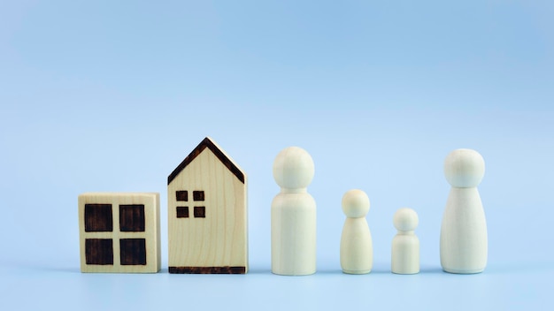Modelo de casa de diferencia y familia de madera sobre fondo azul pastel