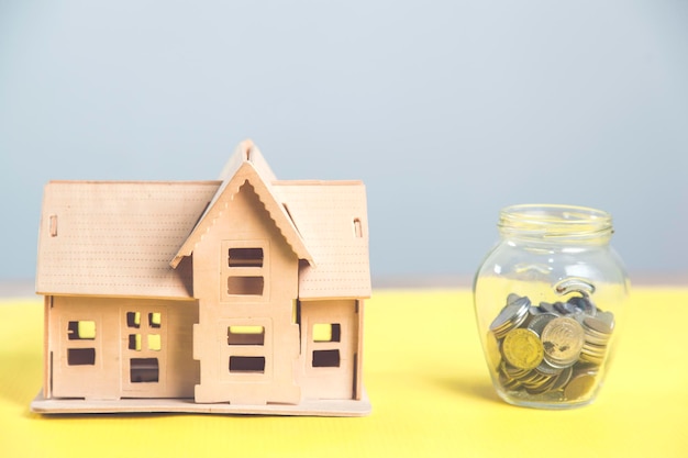 Foto modelo de casa de madera con monedas