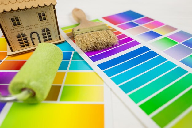 Modelo de una casa de madera con paleta de colores y pinceles