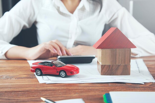 Modelo de casa de mano de mujer con coche