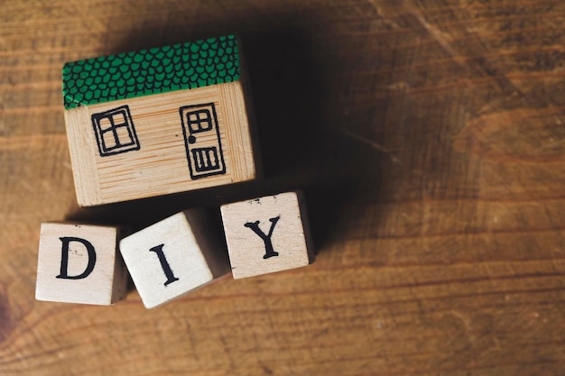 Modelo de casa con palabra DIY hecha de bloques de madera.