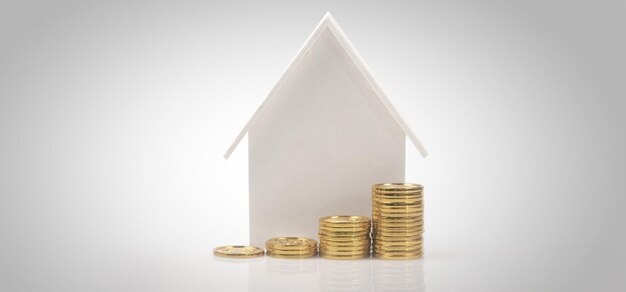 Modelo de casa simulada y monedas propiedad concepto de inversión inmobiliaria