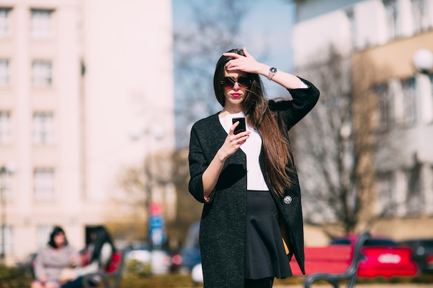 Modelo casual com telefone na rua