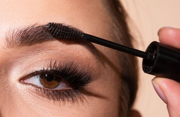 Modelo de cejas hermosa dama encantadora con la belleza de la cara saludable piel clara sostiene el pincel en la mano y