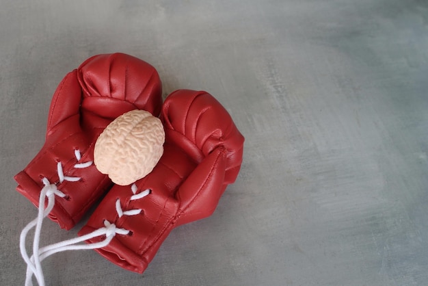 Modelo de cerebro humano encima de guantes de boxeo con espacio de copia Concepto de lucha contra enfermedades cerebrales