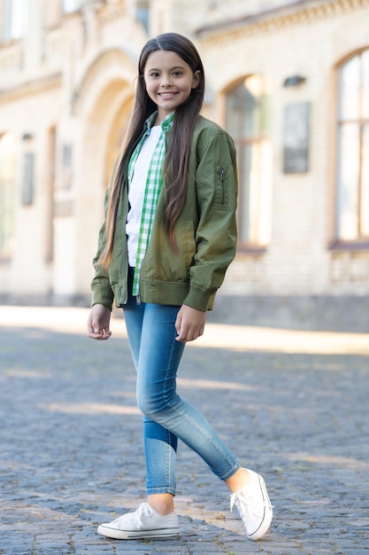 Modelo de chica adolescente feliz posando en estilo casual de moda al aire libre