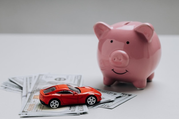 Foto modelo de coche de juguete rojo con hucha y dinero