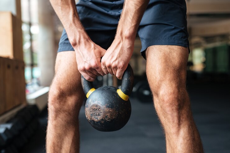 Foto modelo com kettlebel nas mãos. preparando para fazer os exercícios
