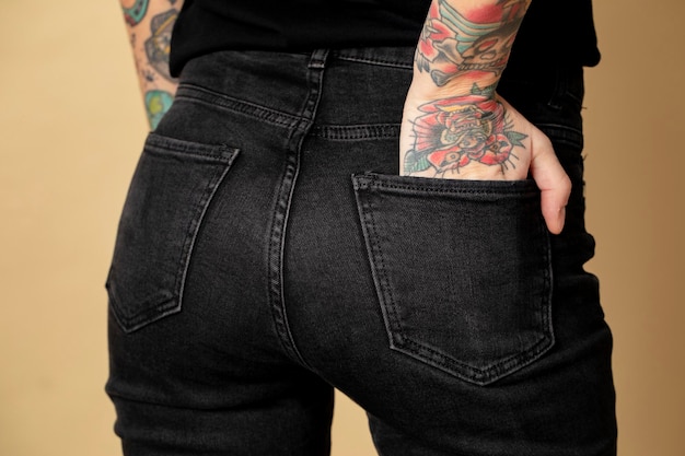 Modelo com tatuagem em camiseta preta e jeans