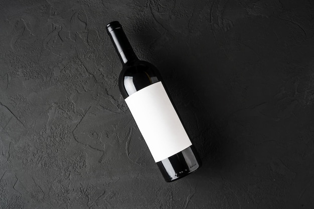 Modelo com um rótulo em branco para uma garrafa de vinho tinto em um fundo escuro