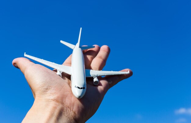 Modelo de avião à disposição no céu ensolarado. Conceitos de viagem, transporte, transporte, sonhando com férias