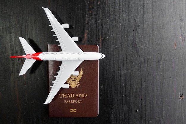 Modelo de avião e passaporte em mesa de madeira conceito de viagem pronto