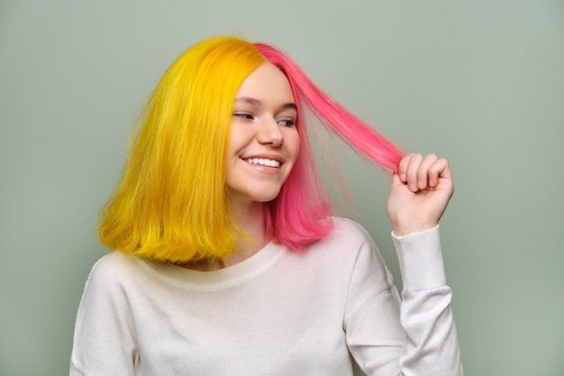 Modelo de beleza de moda de menina de cabelo comprido tingido mostrando coloração em seu cabelo