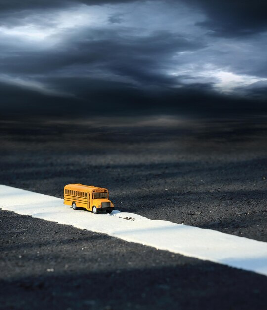 Modelo de brinquedo de ônibus escolar na estrada ruralCenas crepusculares