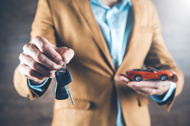 Modelo de carro de mão de homem com chave em fundo escuro