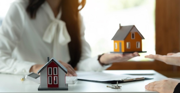 Modelo de casa com agente e cliente discutindo contrato para comprar seguro ou empréstimo imobiliário ou propriedadexA