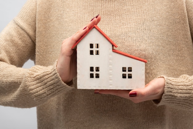 Modelo de casa em mãos femininas